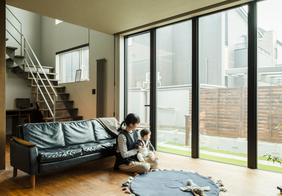 リビングで子どもと過ごす家族の写真